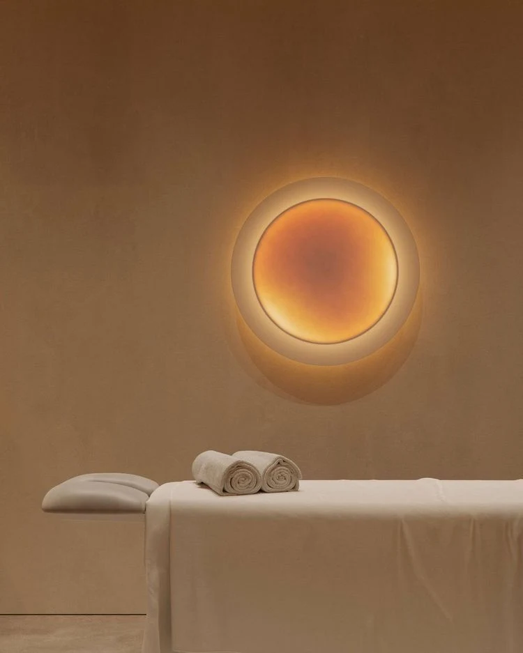 Warm circular wall light in a serene studio interior